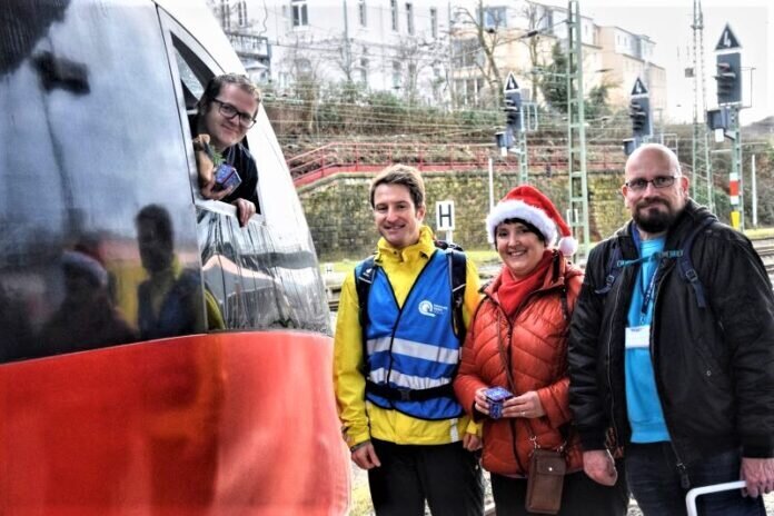 Aktive bei der Verteilaktion an Gleis 9 des Gießener Bahnhofs an Heiligabend an einem Zug des RE25 Gießen-Koblenz.